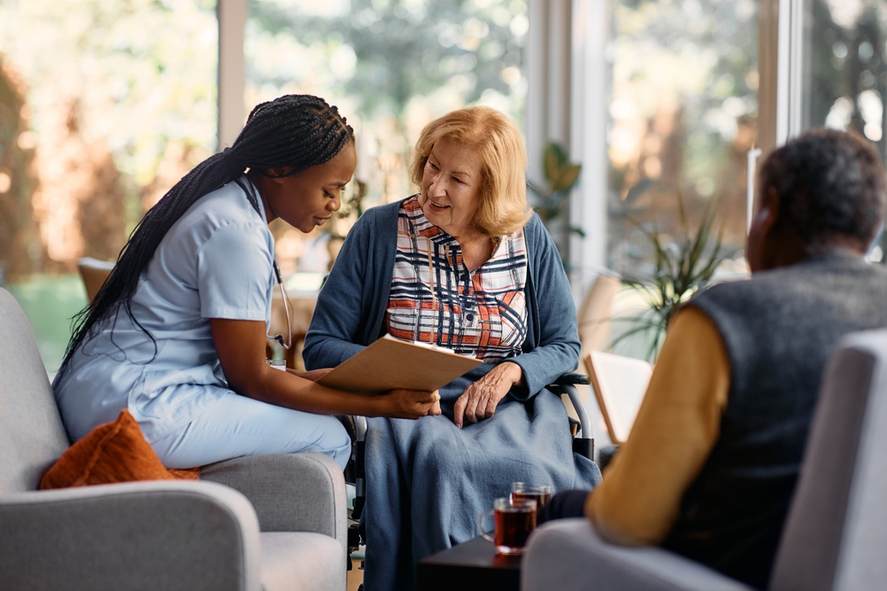 Nurse,Analyzing,Senior,Woman’s,Medical,Record,While,Talking,To,Her